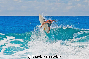 A surfer is frozen in time and space as he carves out the... by Patrick Reardon 